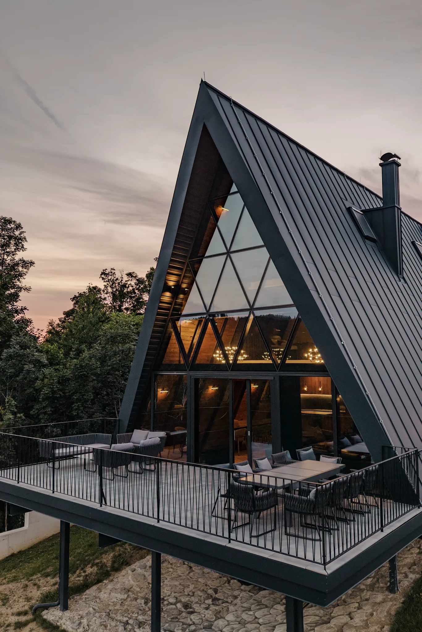The Frame — the A-frame villa and its 13-metre glass wall at dusk